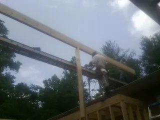 Carpenter setting a ridge beam over a new addition frame — Ice Dam Removal by Roofing Brothers in Hillrose