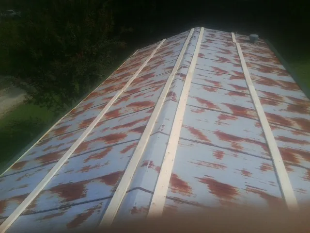 Rusted metal roof panels with new wood purlins before replacement — Storm Damage Roof Repair in Hillrose by Roofing Brothers