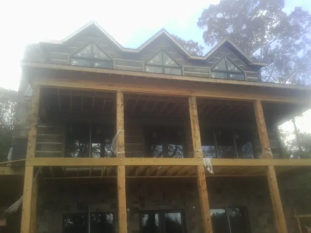 Dormers and porch framing on a large log home under construction — Roof Coating work by our crew in Hillrose